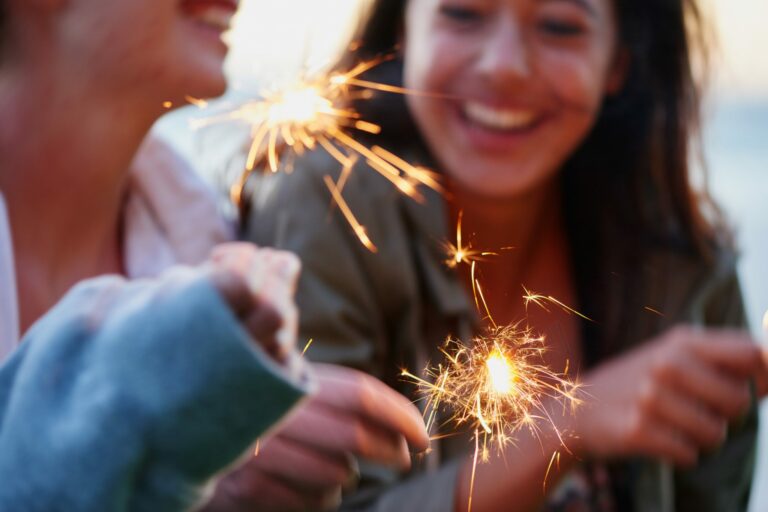 Teenage girls celebrating and laughing with bright sparklers