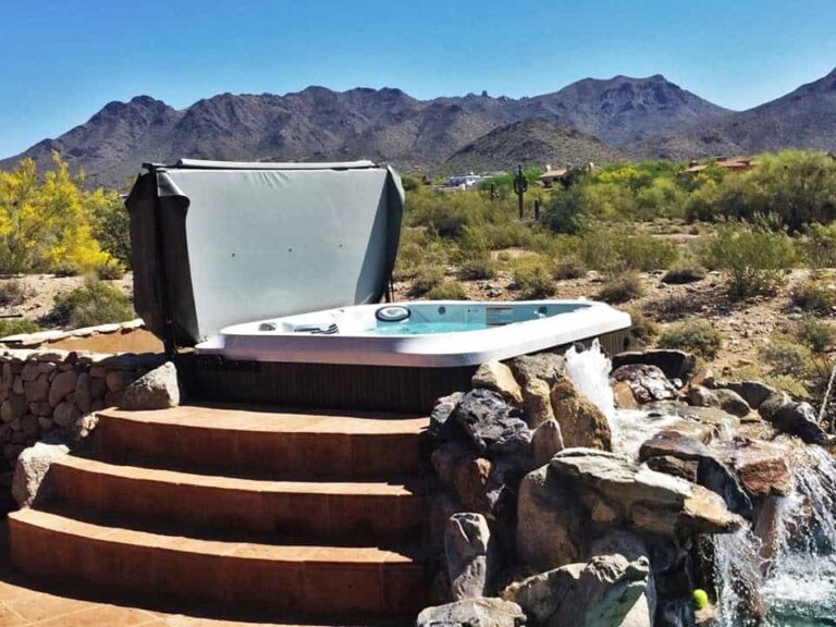 Jacuzzi hot tub installation with custom steps and waterfall mountain view