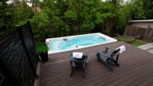 Hydropool swim spa beside a deck with two chairs - swim spa service