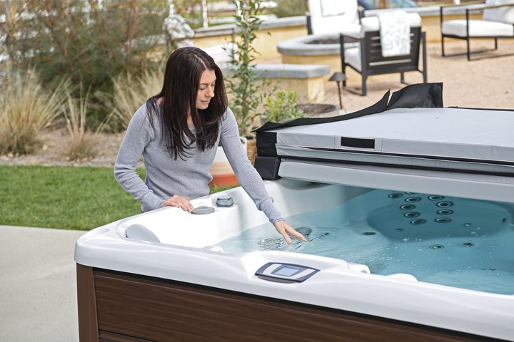 bromine vs. chlorine - woman checking her hot tub water 